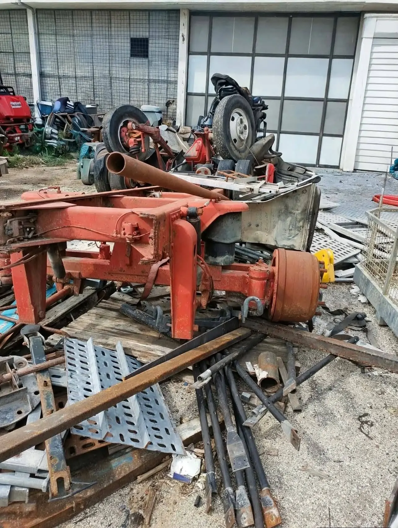 Telaio rosso e rottami metallici in un piazzale